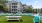 a group of chairs and tables in a grassy area next to a building