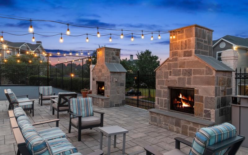 a patio with chairs and a fire pit